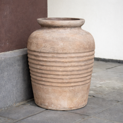 Weathered terracotta jar by the wall